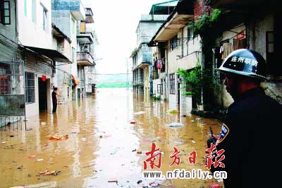 連州市區出現水浸,一位干警在受災點巡邏。　　梁有華陳楚然攝