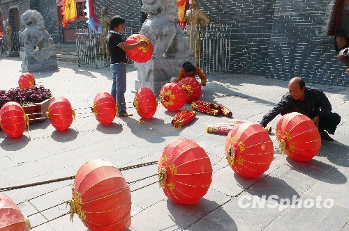 8月31日，河南省開封市天波楊府門口，工作人員在準備懸掛大紅燈籠。隨著“十一”國慶節和“十一”旅游黃金周的臨近，古城開封的公園景點已早早開始備戰，營造喜慶祥和的旅游環境，迎接八方客人。 中新社發 李俊生 攝