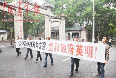 5月21日，文強被宣判死刑后，重慶群眾自發來到重慶市委門前，打出條幅：“打掉黑社會保護傘文強，黨和政府英明！” 本報記者 田文生攝