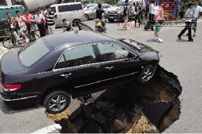 4日，南昌市昌南大道與迎賓北大道交叉口附近路面突然發生塌陷，一輛過路小轎車被卡在洞口處。圖/新華社