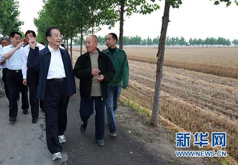 這是6月9日，溫家寶在長(zhǎng)葛市石象鄉(xiāng)坡李王村的田間小路上與坡李王村支部書(shū)記李福成邊走邊聊。新華社記者龐興雷攝