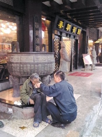 8月25日，網友申超在街頭拍下的張副山喂老人吃面一幕。 