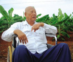 陳光保在自己的農場里，他身后就是一片香蕉林(中青報蔣昕捷供圖)