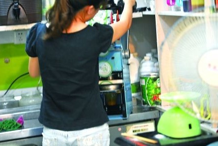 昨日，沙坪壩區(qū)一飲料店，店員在用添加劑勾兌果汁