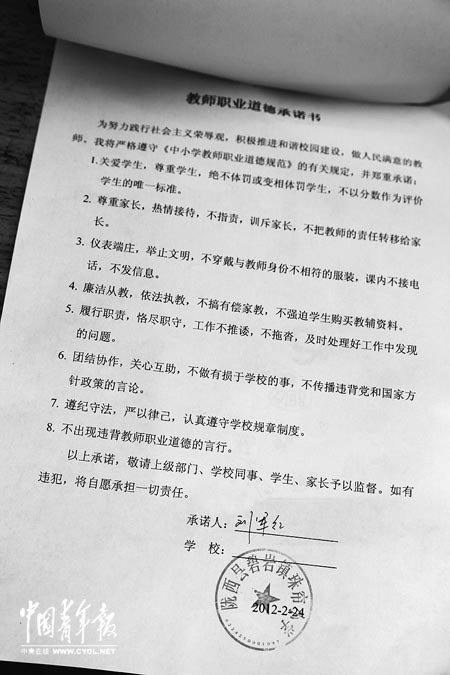 劉軍紅簽字的教師職業(yè)道德承諾書。本報記者 張鵬攝