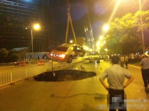 吊車將墜入塌陷坑的汽車吊出。圖/末代小王爺