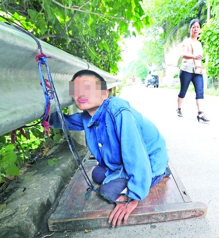 江津白沙鎮,被捆在公路邊的何貴明。 首席記者 鐘志兵攝