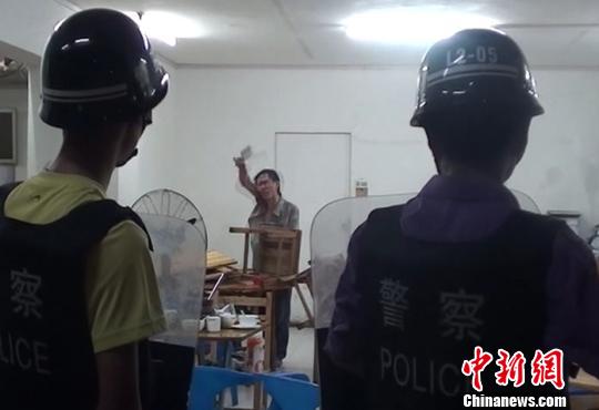 圖為涉嫌販毒的男子持菜刀在宵夜店與民警對峙。 劉志強 攝