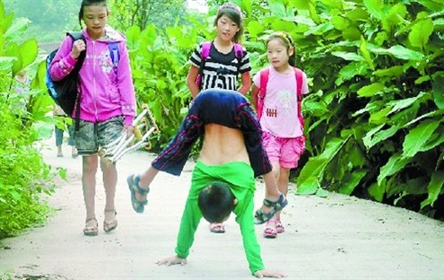 倒立行走去上學 堅強癱瘓男孩感動網友。圖據山東商報