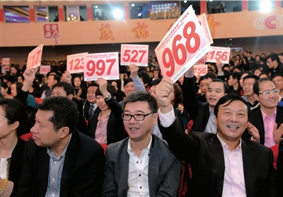 昨天，在央視2013年黃金資源廣告招標競購大會現場，企業代表舉牌競標。圖/CFP