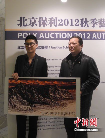 田亮與畫家洪潮合影，兩人展示《夢縈釣魚島》縮小版。