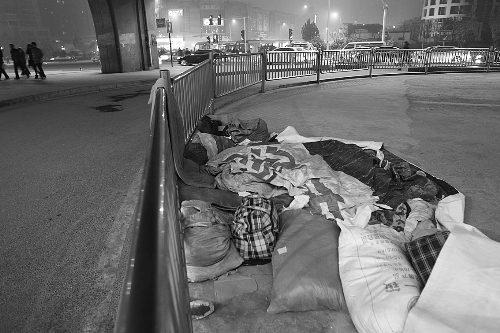 農民工露宿地的不遠處，夜幕下車來車往