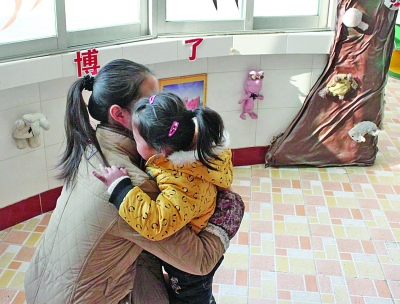 江都商貿幼兒園一位老師在擁抱該園的孩子。因為涉及收費，作為該園精品教育的一個項目，老師的擁抱行為也被質疑。 董鑫 攝
