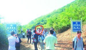 被困女子（圈中）獲救后從山嶺入口處豎有“軍事禁區”的標牌旁通過。