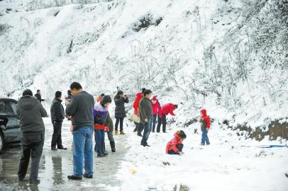 乘客在土山崗停車區休息時拍照賞雪。張磊攝