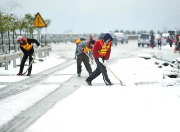 工作人員清理高速路上的積雪。 張磊攝