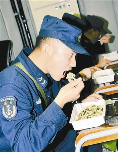 “青島”艦上的官兵在戰位上吃野戰快餐。解放軍報 記者 米晉國攝