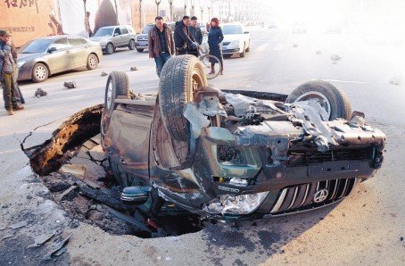 沈陽一道路現大坑 霸道車遭橫禍四腳朝天(圖)