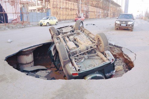 沈陽一道路現大坑 霸道車遭橫禍四腳朝天(圖)