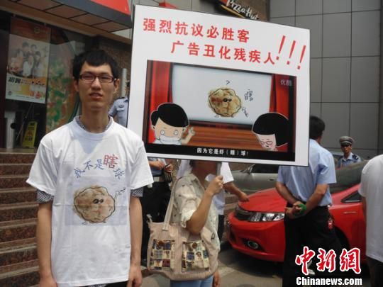 6月5日，視障人士在鄭州一必勝客門前舉牌抗議蝦球廣告歧視。 門杰丹 攝